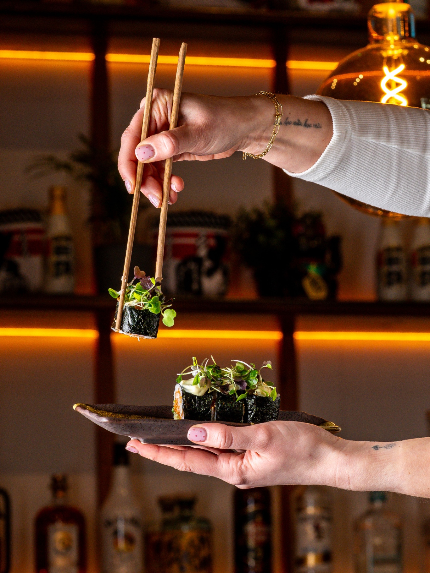 Chef serving maki with chopsticks
